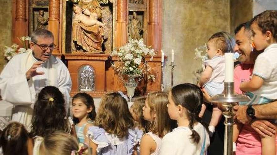 El párroco, Miguel Ángel García Bueno, otorga la bendición de la Virgen del Valle a los niños de Pravia.