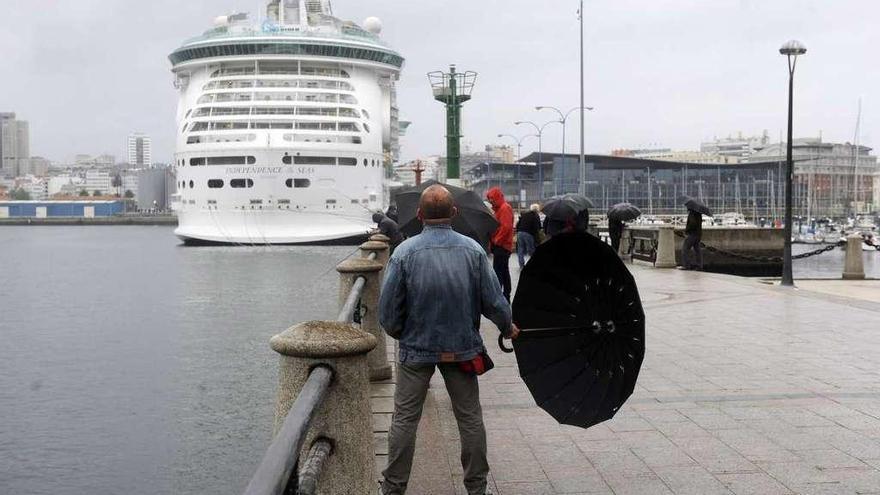 Gente paseando por A Coruña con paraguas debido a una borrasca.