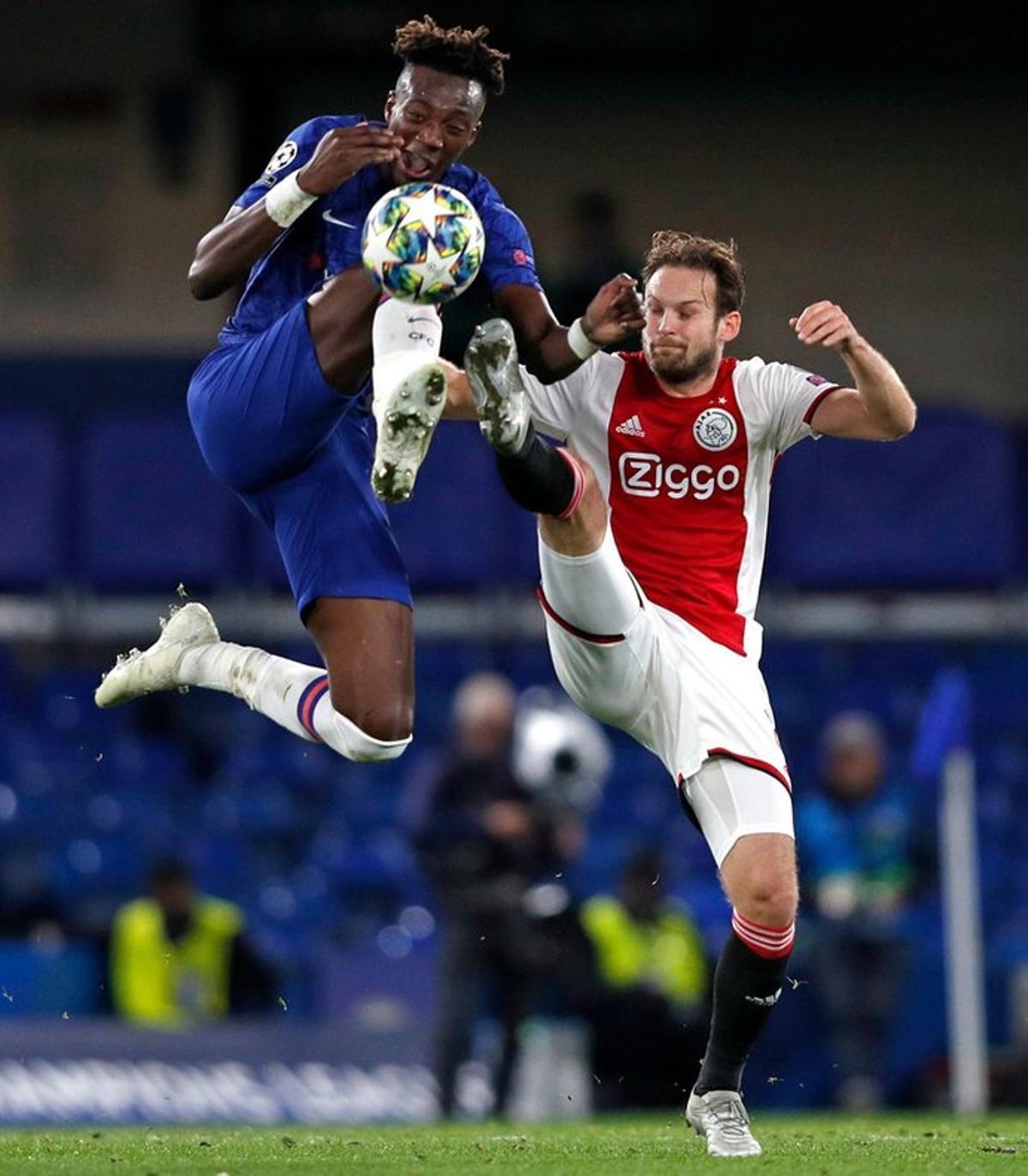 El delantero inglés del Chelsea, Tammy Abraham (L) compite con el defensor holandés del Ajax Daley Blind (R) durante el partido de fútbol del Grupo H de la Liga de Campeones de la UEFA entre el Chelsea y el Ajax en Stamford Bridge.