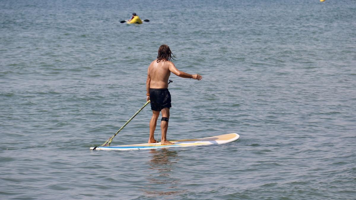 Un home fa 'paddle surf' a la platja de Ribes Roges, a Vilanova i la Geltrú.