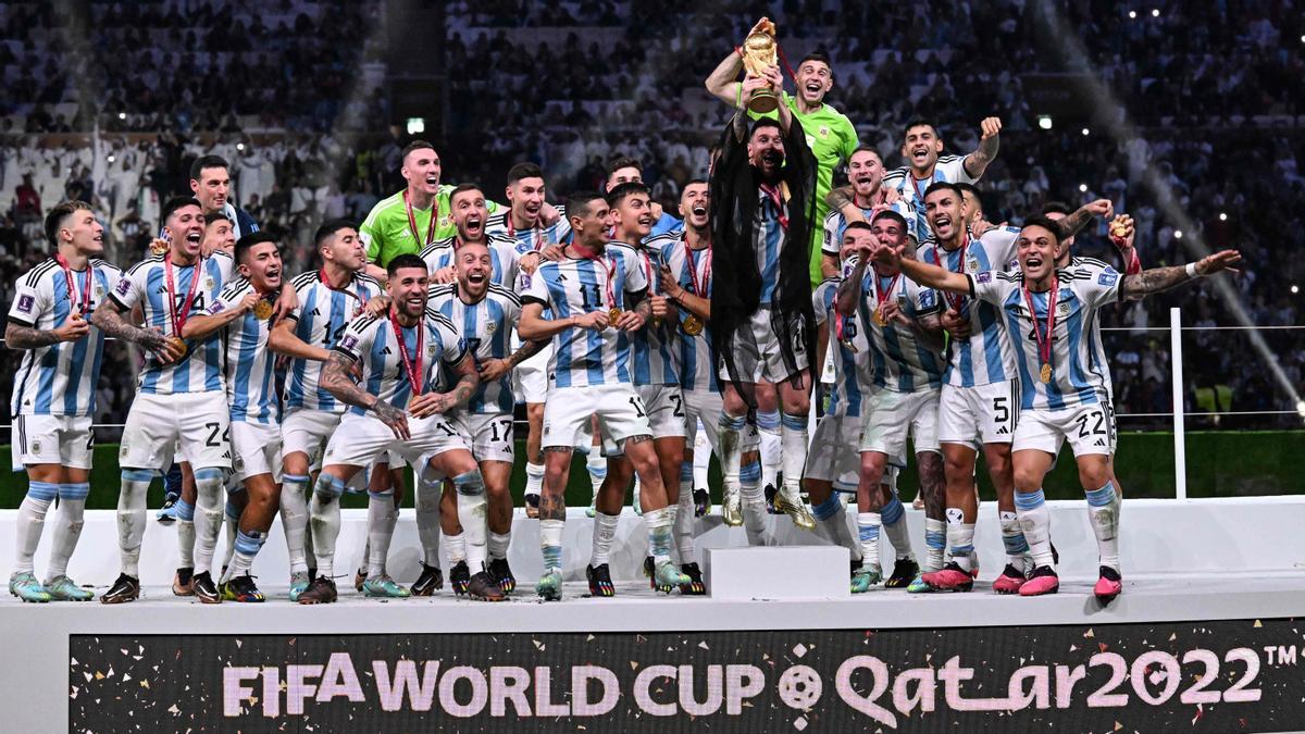 Messi sostiene el Trofeo de la Copa Mundial de la FIFA, mientras celebra con sus compañeros ganar el partido de fútbol final de la Copa Mundial Qatar 2022 entre Argentina y Francia en el Estadio Lusail.