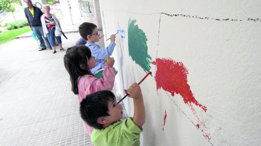 Los pequeños pintan su cuadrante de la pared, con formas o todo del mismo color.