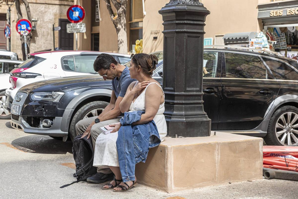 Dos turistas descansan en una de las bases que ya han empezado a reformarse.