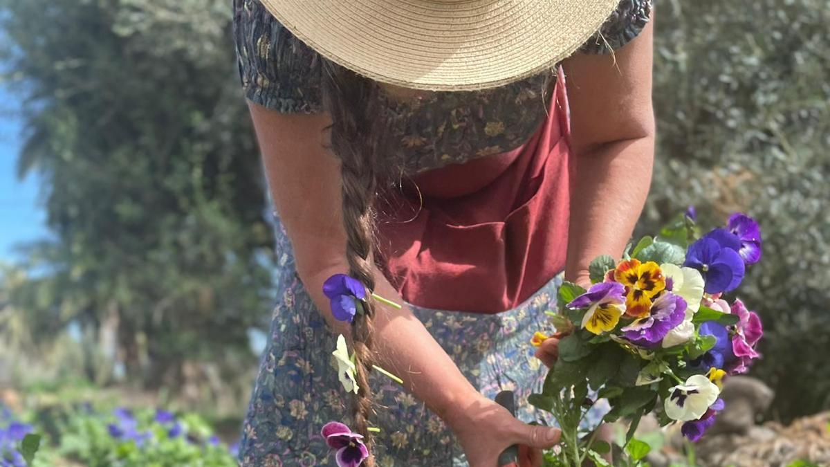 Rosi Campos, tijera en mano, hace acopio de una cosecha de flores en la finca de Santa Brígida.