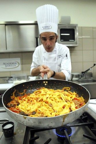 Chef Tommaso Moroni cooks pasta with sauce at the Barilla Academy in Parma