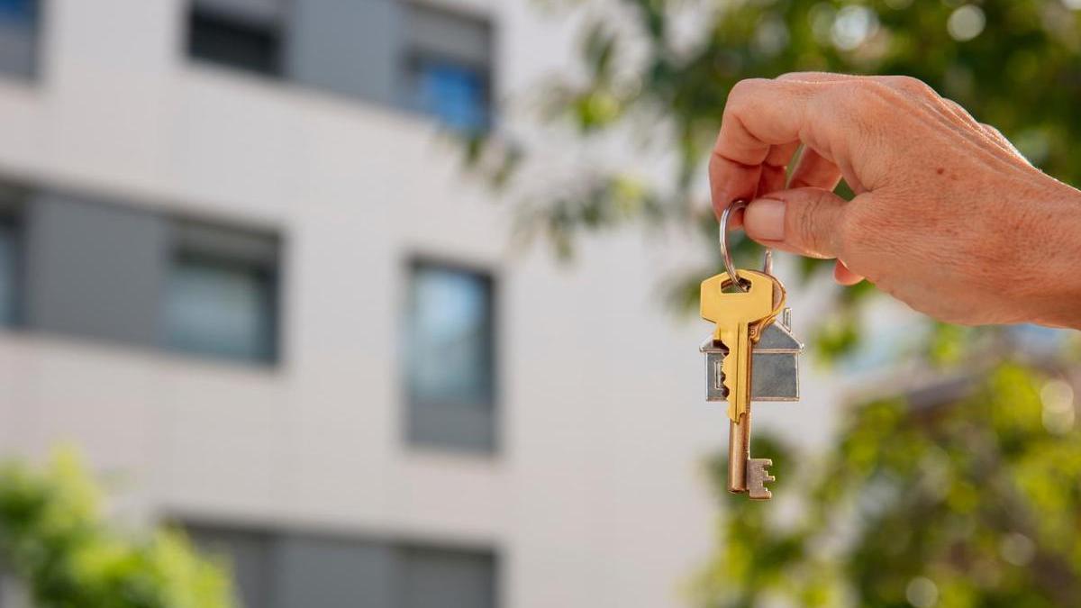 Una mujer muestra las llaves de una vivienda.
