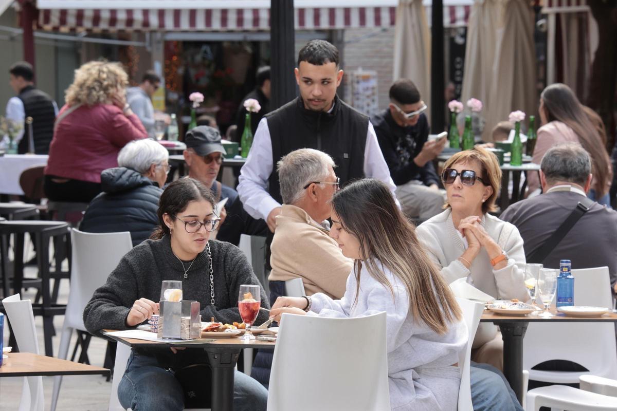 Un camarero de un negocio  hostelero de la Plaza de las Flores de Murcia atiende a los clientes.