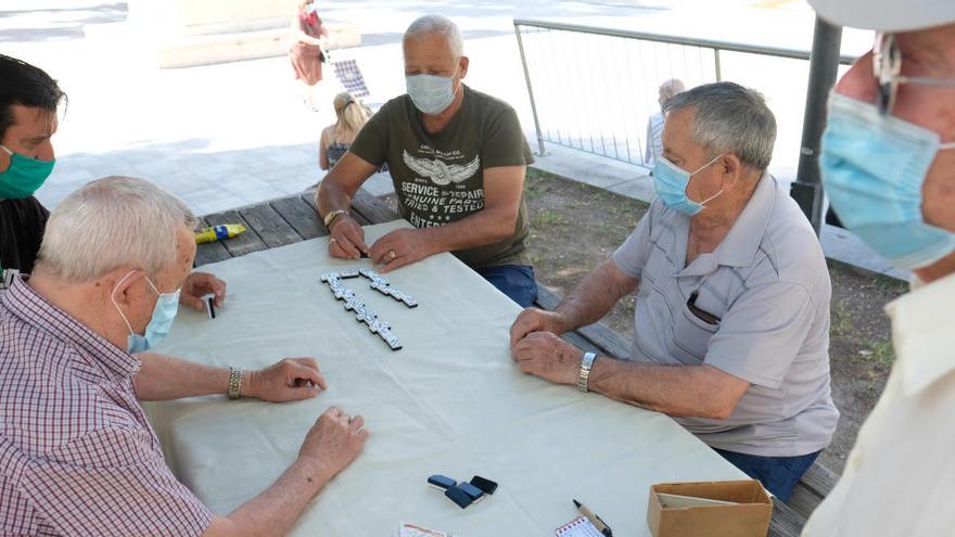 Varias personas juegan una partida de dominó