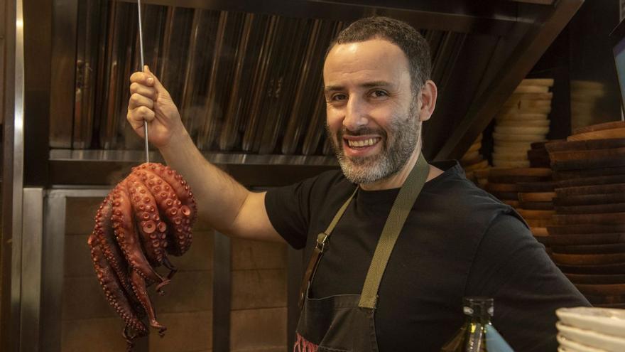 El chef Gorka Rodríguez posa con su producto estrella, el pulpo, en la cocina de La Pulpeira de Melide. |  Casteleiro/Roller Agencia