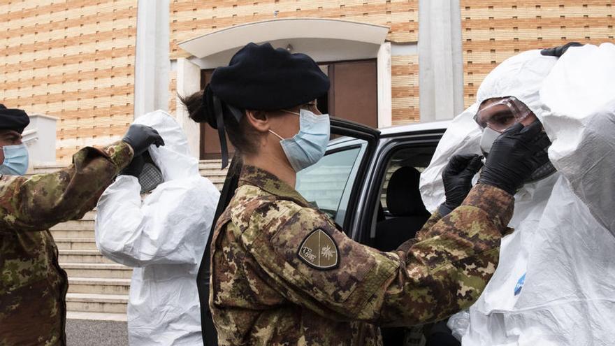 Soldados italianos se preparan para sanear una parroquia durante la fase 2 de la pandemia.