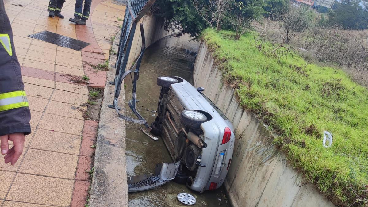 Un coche cayó este domingo a la red de canalización de aguas, en una rotonda de Churriana, tras salirse de la vía a causa de un vertido de combustible
