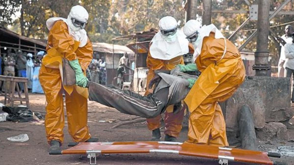 Sanitarios de la OMS retiran el cadáver de un enfermo de ébola en Guinea, el pasado enero.