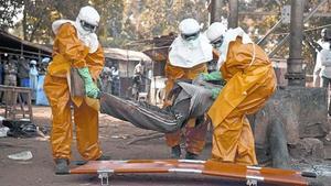 Sanitarios de la OMS retiran el cadáver de un enfermo de ébola en Guinea, el pasado enero.