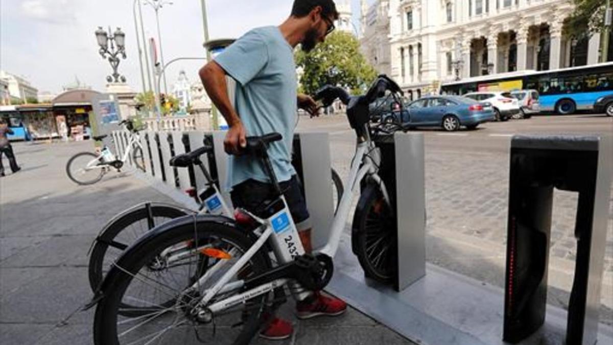 Un usuario del BiciMad se dispone a coger una bicicleta en el centro de Madrid.