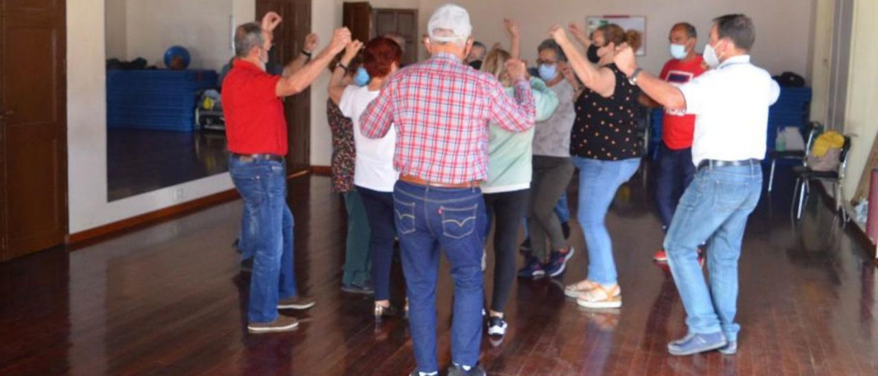 Un grupo de vecinos de La Orotava participa en una actividad de baile en el Centro Municipal de Mayores.