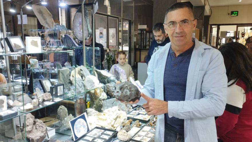 José Vicente Casado, el «Cazameteoritos», ayer, con uno de ellos en las manos en el certamen de minerales, gemas y fósiles de la Escuela de Minas. | F. V.