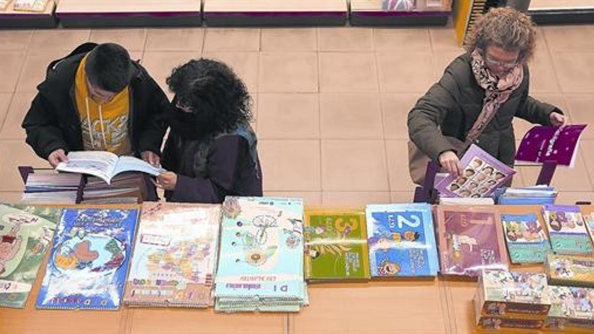 Unos clientes consultan libros de texto en una tienda Abacus, en Barcelona.