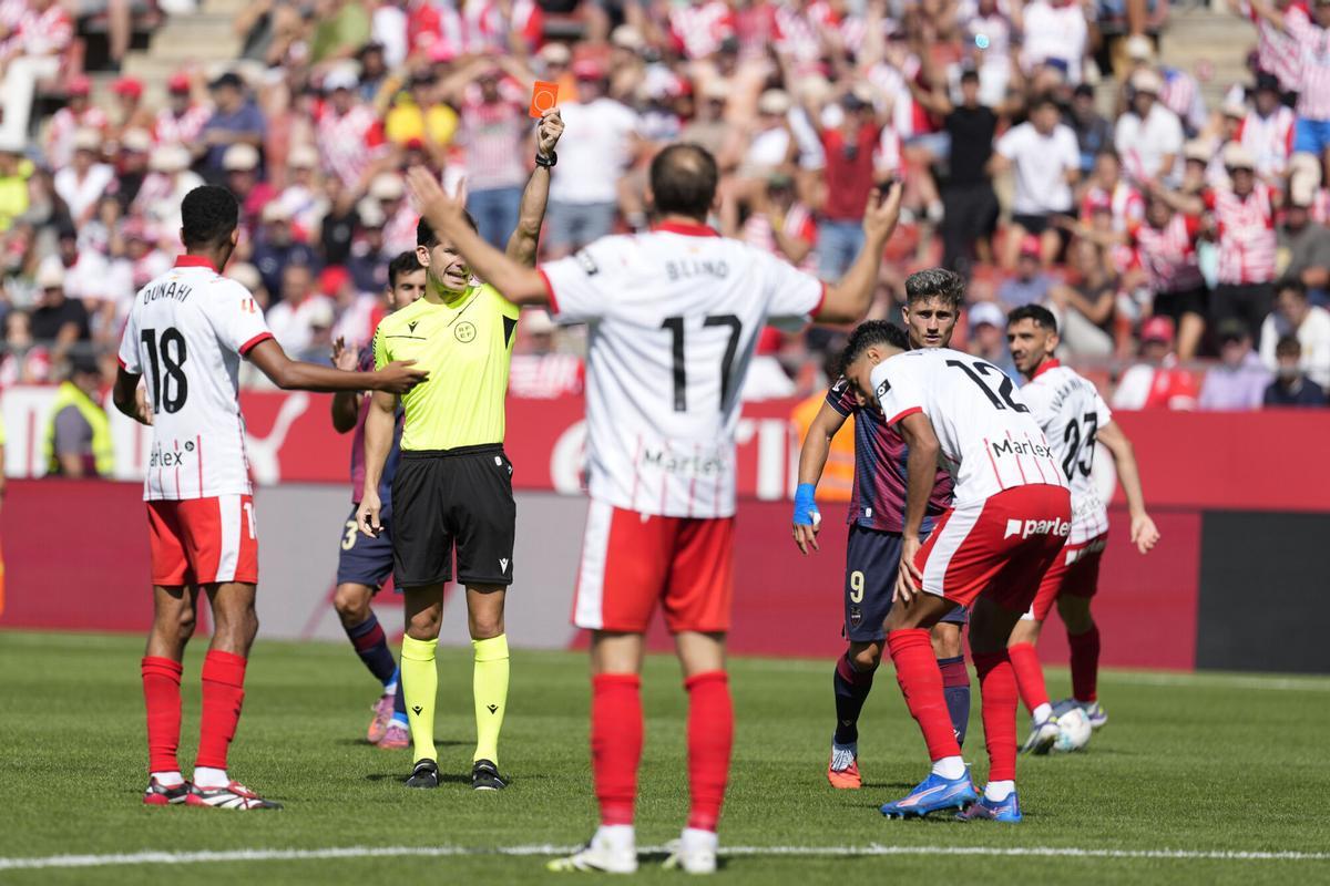 El defensa del Girona FC, Vitor Reis (d) ve la tarjeta roja durate el partido de LaLiga disputado en el estadio municipal de Montilivi en Girona. EFE/David Borrat