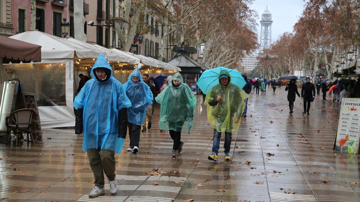 Gente de paseo por la Rambla de Barcelona bajo la lluvia, el pasado día 19.