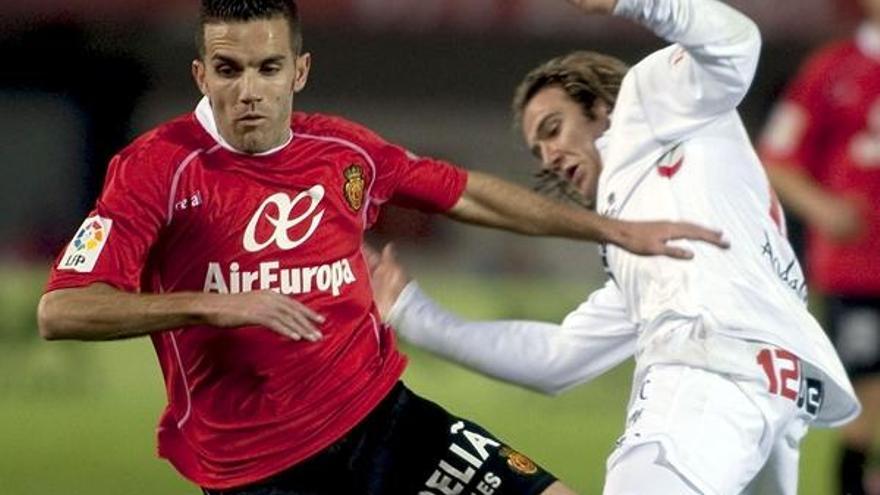 El jugador del RCD Mallorca, Julio Alvarez, cae ante el delantero del Sevilla, Diego Capel,