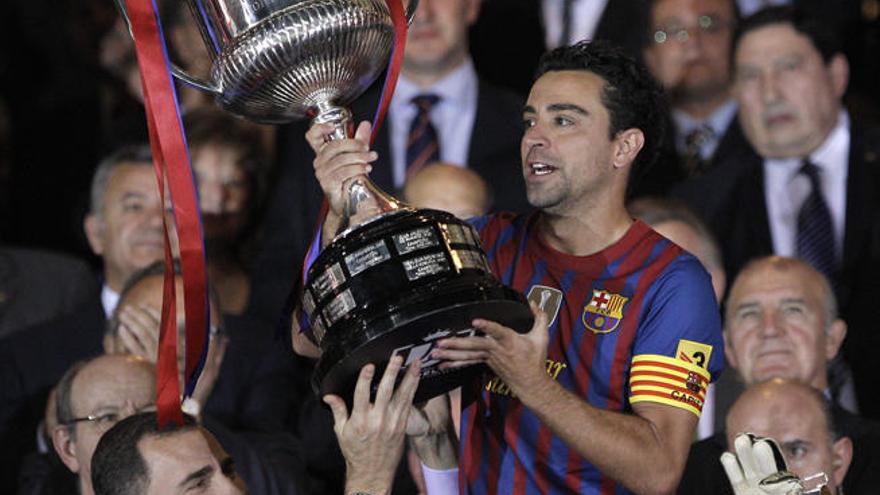 Xavi levanta uno de los 25 títulos conquistados: la Copa del Rey de 2012 .