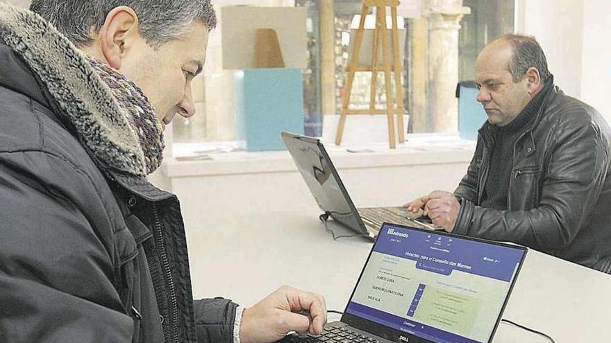 Miembros de En Marea participando en la votación en su sede de Santiago ayer.