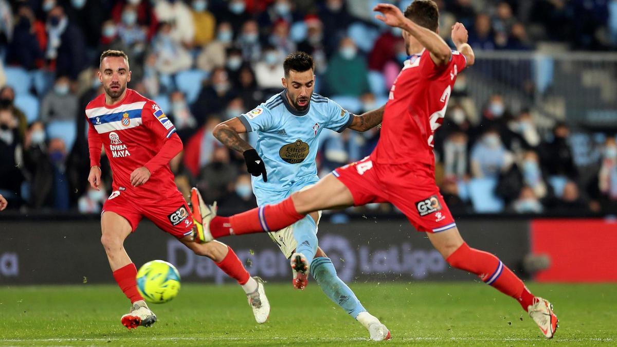 El centrocampista del Celta de Vigo Brais Méndez (c) centra el balón defendido por Sergi Gómez, del RCD Espanyol.