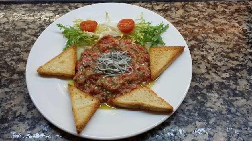 Tartar de salmón salvaje con angulas en ensalada .