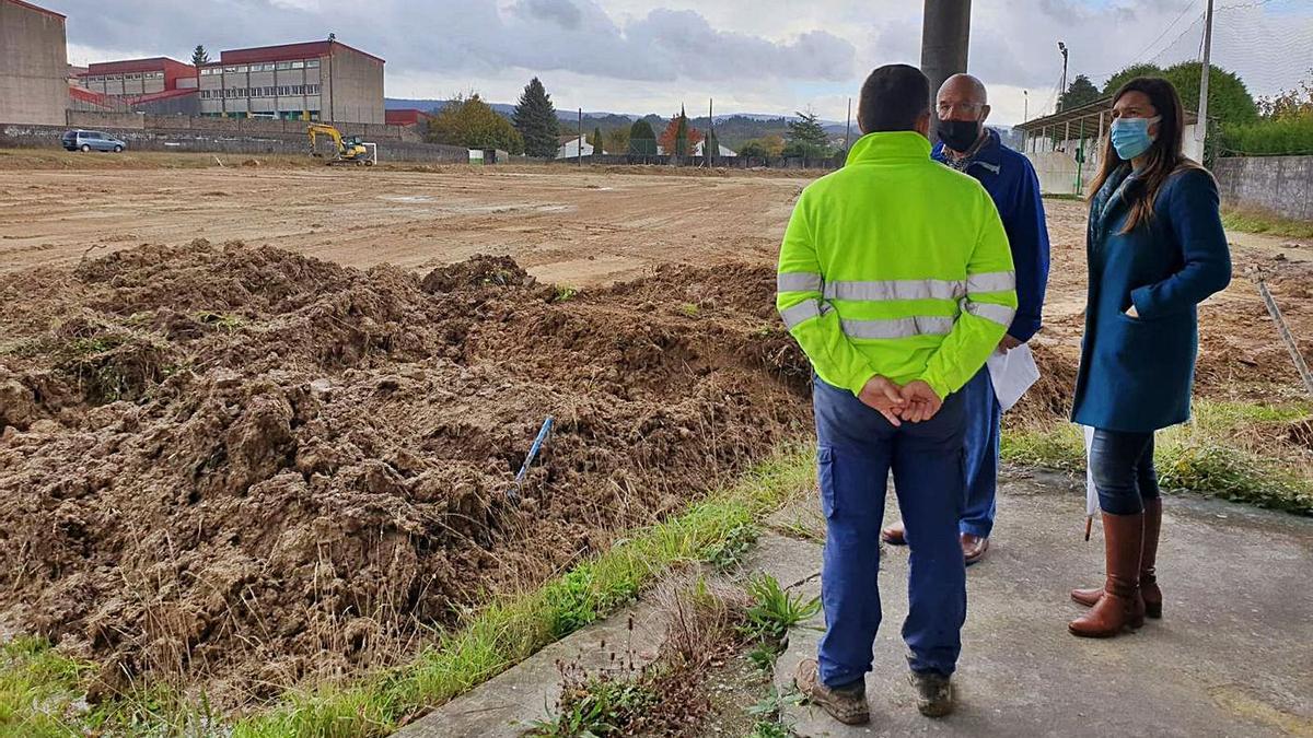 La alcaldesa de Forcarei, yer, con responsables de Limonta Sport Ibérica en el campo de fútbol. |