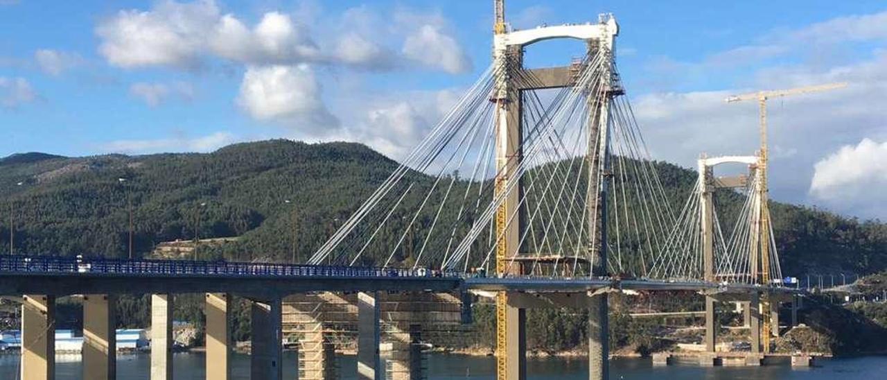 El asfaltado de los nuevos carriles centra ahora los trabajos en el viaducto | Día y noche, los siete días de la semana. La ampliación del puente de Rande (en la imagen) encara la recta final con una frenética actividad que persigue el objetivo de concluir el proyecto antes de finalizar el año para que Audasa pueda subir los peajes en enero. Los trabajos se centran estos días en el asfaltado de los nuevos carriles. Buena parte de los viales que parten desde Redondela hasta el primer pilar ya lucen la calzada que estrenarán los conductores en Navidades. En el otro lado de la ría, en Domaio, la aplicación de esta capa asfáltica avanza a menor ritmo condicionada por la conexión con la autovía de O Morrazo.