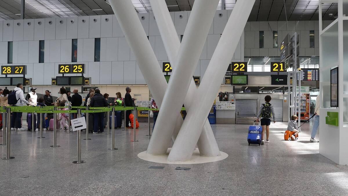 Pasajeros en el aeropuerto de Santiago facturan su equipaje antes de tomar un vuelo