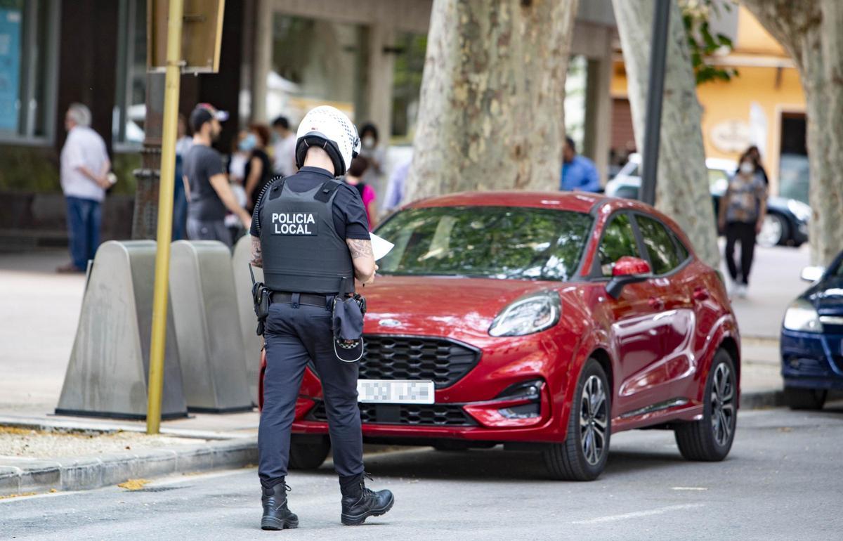 Una gente de la Policía Local denuncia un coche mal aparcado en la Albereda de Xàtiva.
