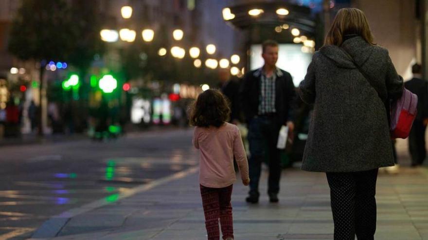 Una mujer camina en compañía de una niña, ayer, en la calle Uría.