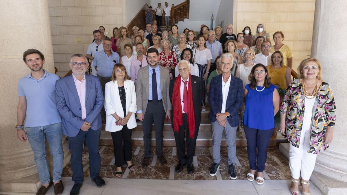 El Padre Ángel, con su inseparable bufanda roja, ayer, junto a las autoridades en Gandia. | ÀLEX OLTRA