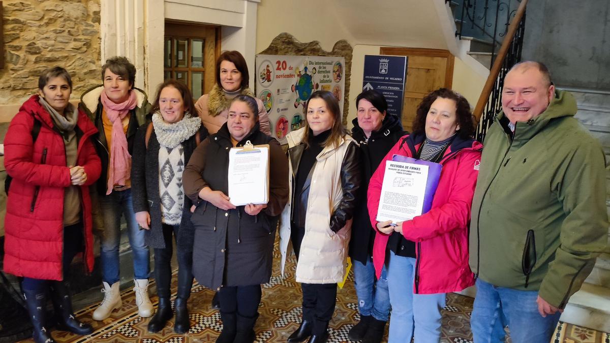 Por la izquierda Lourdes de la Rosa, Clara Basanta, Cristina Quintana, Belén Prieto, Sandra Fernández, Mercedes Martínez, Natalia Álvarez, Josefa Martínez y César Álvarez a la entrada del consistorio veigueño.