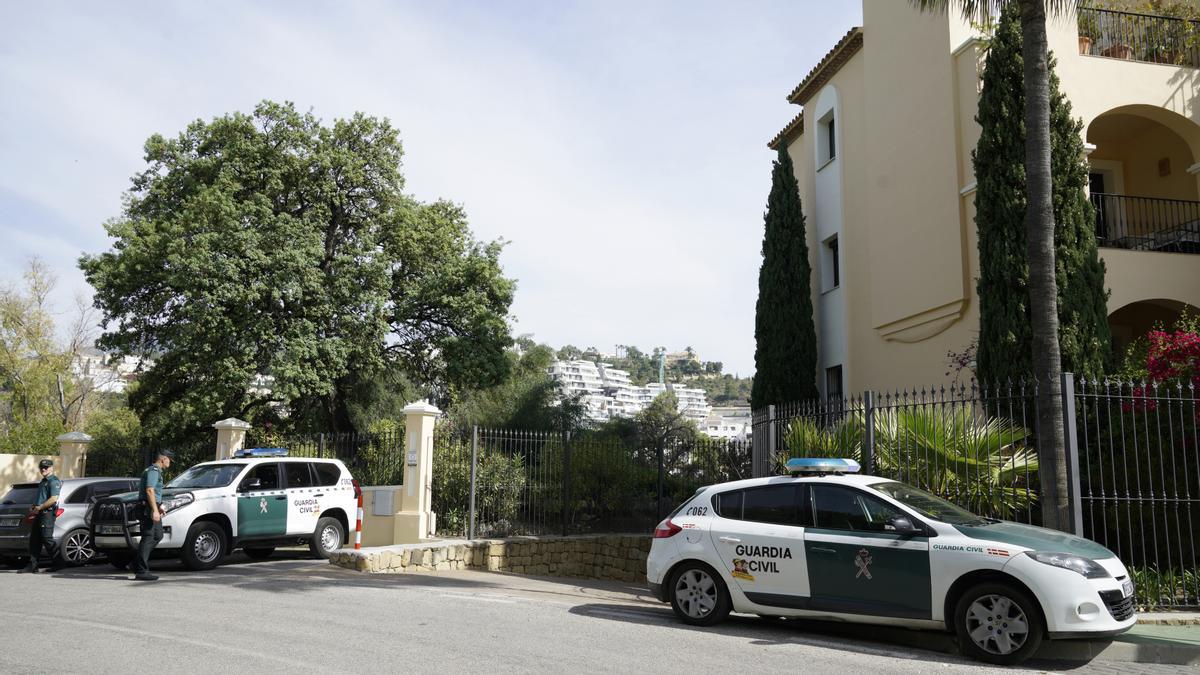 Varios vehículos de la Guardia Civil aparcados en la zona residencial Buena Vista II de Benahavís donde el grupo forense inspeccionan los restos óseos humanos hallados en una maleta.