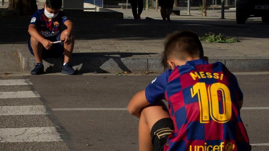 Dos nens esperen capcots l&#039;arribada de Messi a la Ciutat Esportiva Joan Gamper
