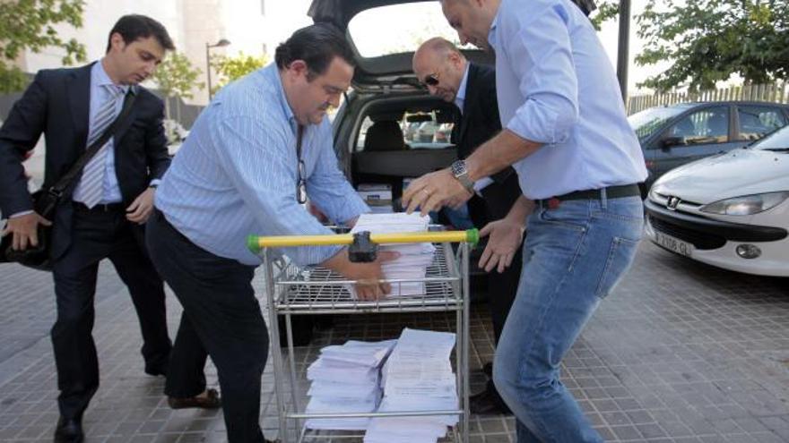 Los procuradores del caso de las ONG con el sumario, ayer antes de llevarlo a fotocopiar.