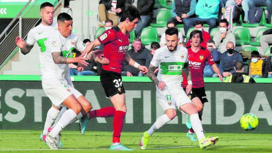 Jesús Vázquez avanza entre dos futbolistas del Elche durante el partido del sábado en el Martínez Valero.  | EFE