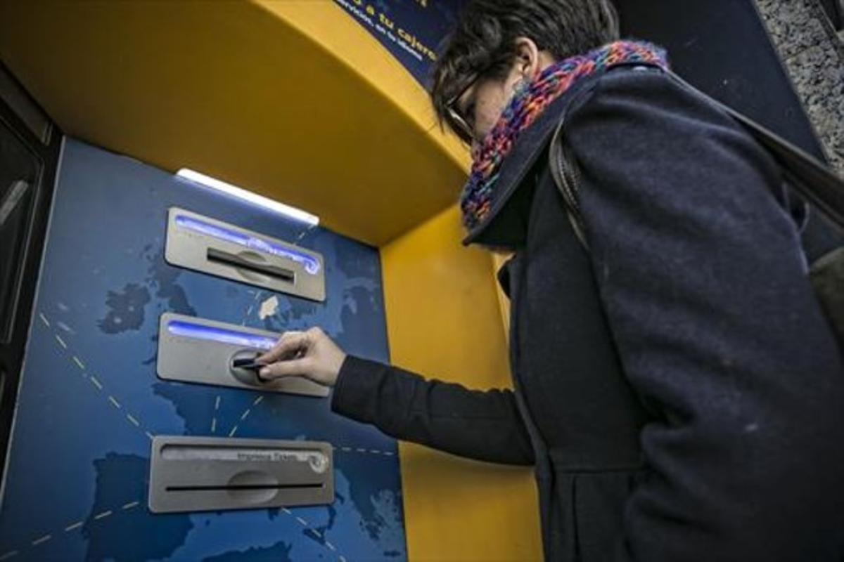Comissions 8 Una clienta bancària utilitza la targeta en un caixer automàtic en una oficina de Barcelona. Comissions 8 Una clienta bancària utilitza la targeta en un caixer automàtic en una oficina de Barcelona.