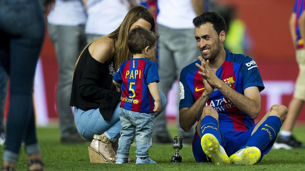 Sergio Busquets con su mujer e hijo sobre el césped del estadio Vicente Calderón tras la victoria en la final de la Copa del Rey contra el Alavés, en mayo de 2017.