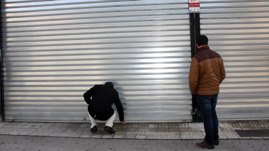 Agents de la policia espanyola retirant el precinte d&#039;un dels establiments tancats