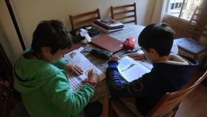 Unos niños haciendo deberes.