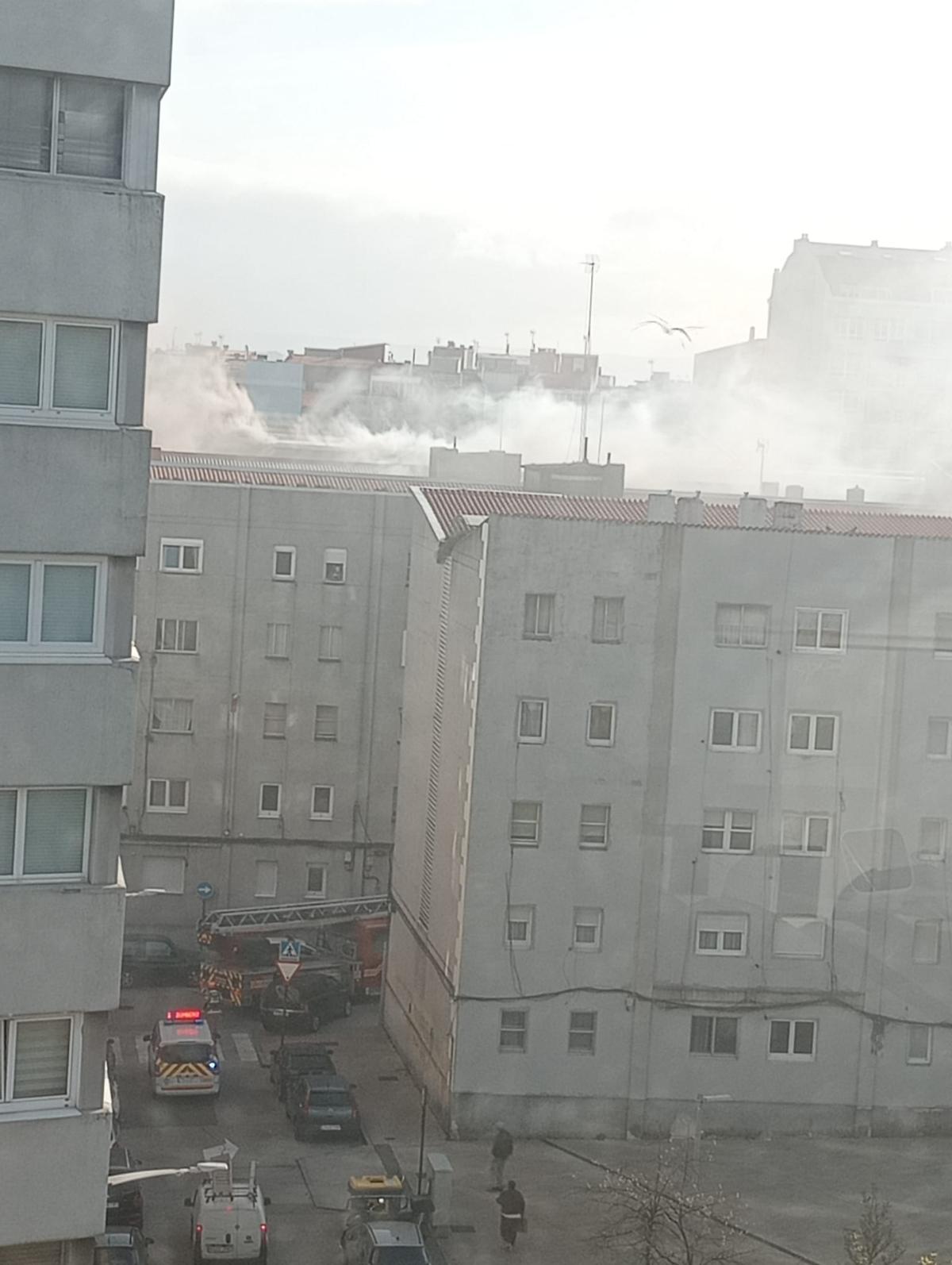 Los bomberos acuden a la calle Mosteiro de Sobrado por un aviso de incendio. En la imagen, humo sobre los tejados de las Casas de Franco.