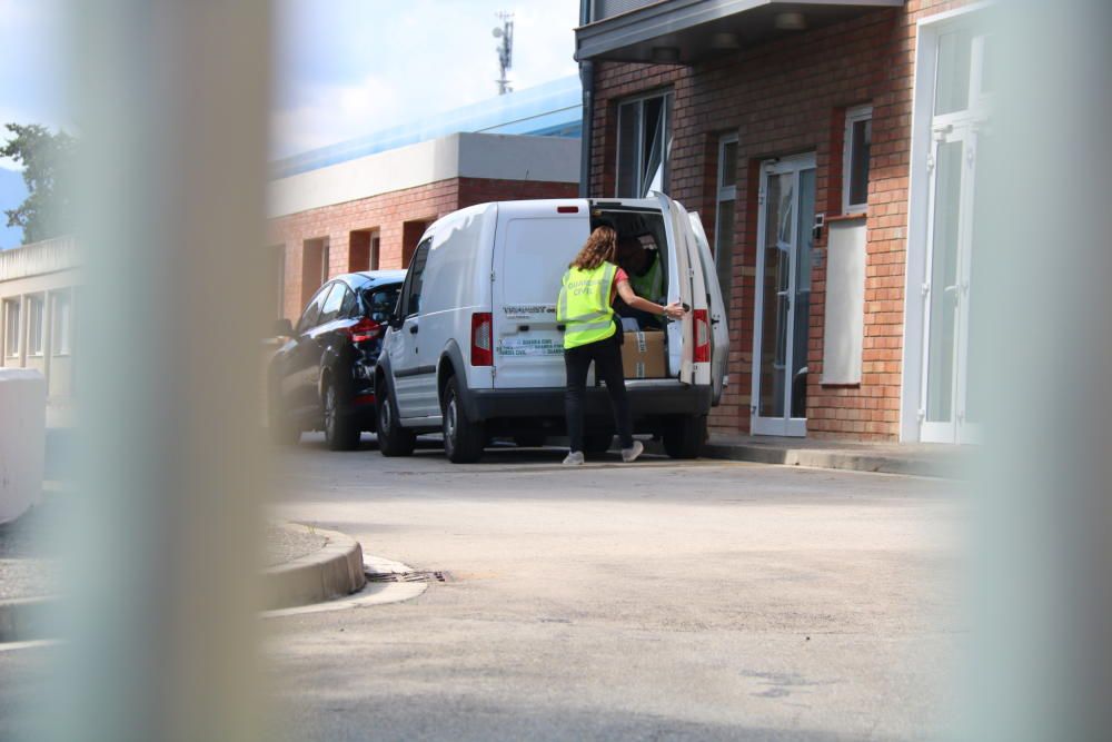 Una policia obre el maleter del cotxe on es veuen caixes durant el registre a la planta potabilitzadora de Montfullà