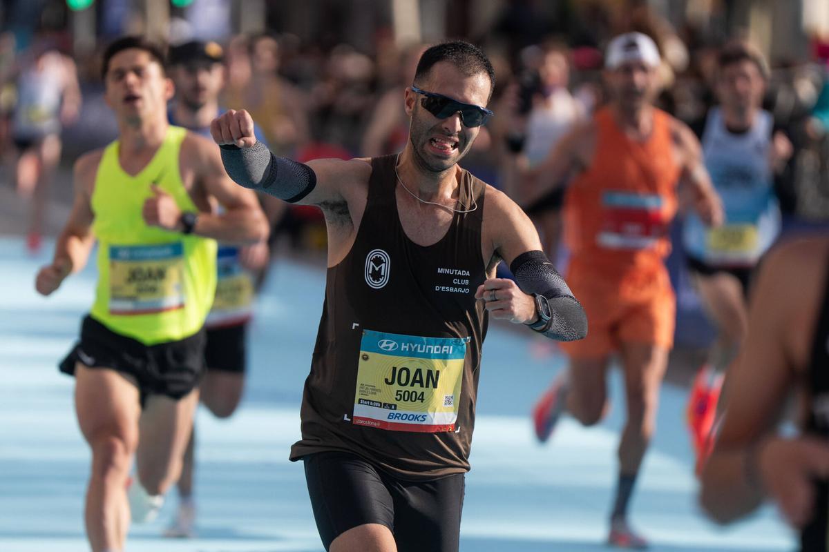 Un corredor saluda a los espectadores en su llegada a la meta.