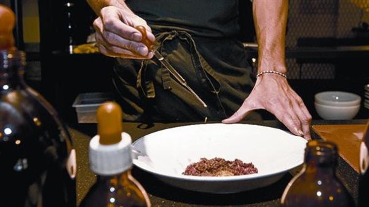 Preparación de un steak tartare en el restaurante Casa Paloma de la calle de Casanova.