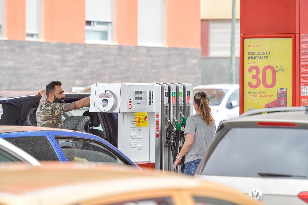 Dos personas repostando en una gasolinera de Canarias.
