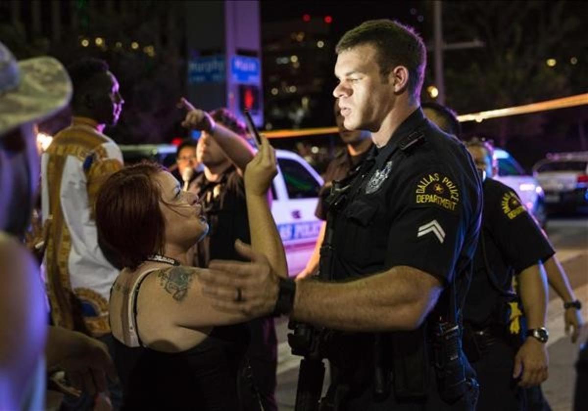 Una mujer graba a un policía durante la protesta.