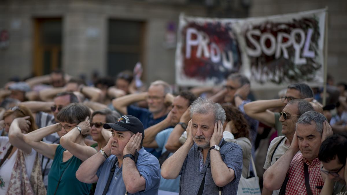 Los manifestantes se tapan los oídos durante la concentración de la xarxa veïnal contra el ruido frente al Ajuntament